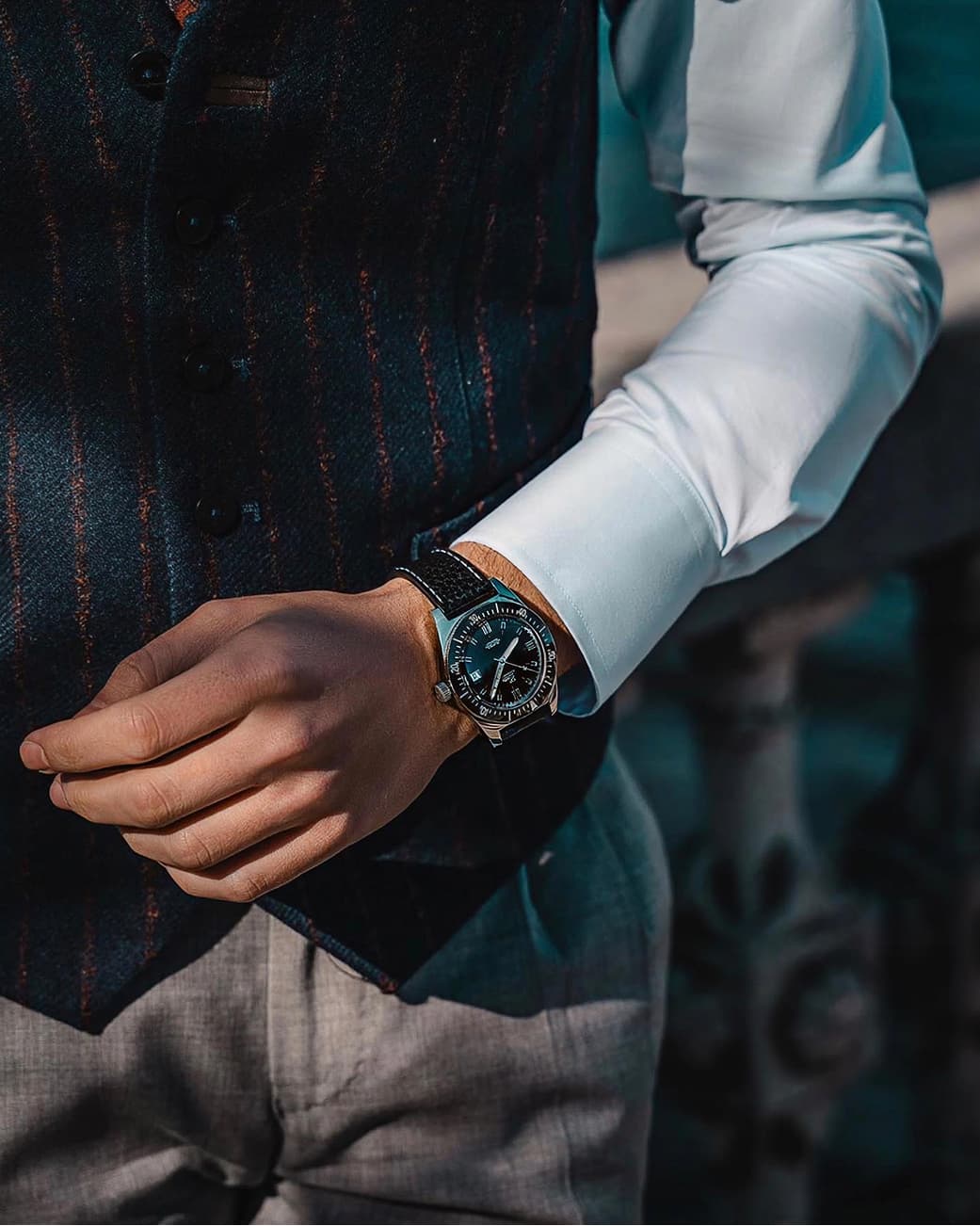 A vintage-inspired watch worn with tailoring in moody lighting